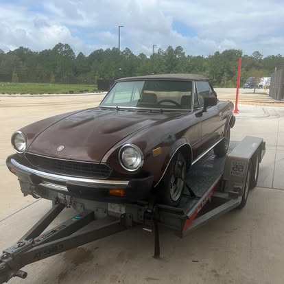 Brown Fiat 124 Spider on a trailer