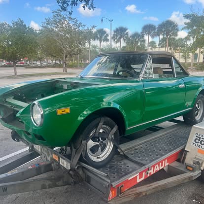 Green Fiat 124 Spider on a trailer